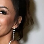 Eva Longoria smiles by a wall