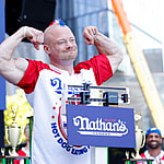 Nick Wehry stands on the scale at the 108th Nathan's Famous Fourth of July International Hot Dog Eating Contest