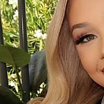 Alabama Barker smiles to the camera.