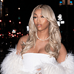 Angel Reese posing in a white dress outside for an event.