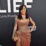Glorilla posing on the red carpet in a gold dress during the Grammys.