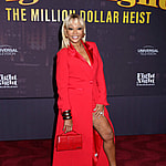 Karen Huger posing in a red dress on the red carpet.