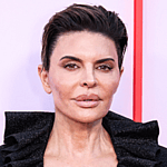 Lisa Rinna posing in a black outfit on the red carpet.