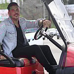 Jax Taylor looking into the camera on a golf cart.