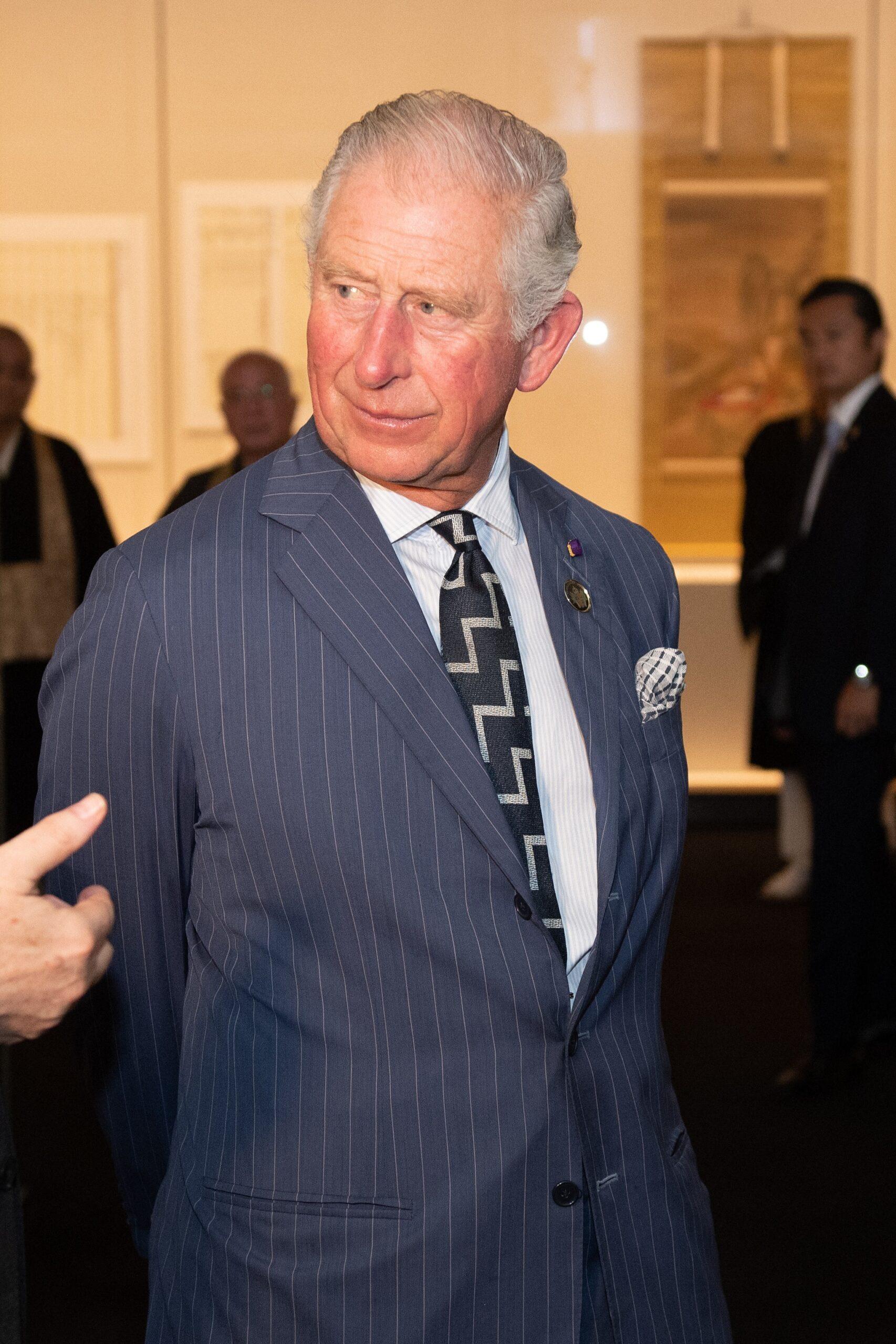 King Charles III in a navy pinstriped suit at a formal event