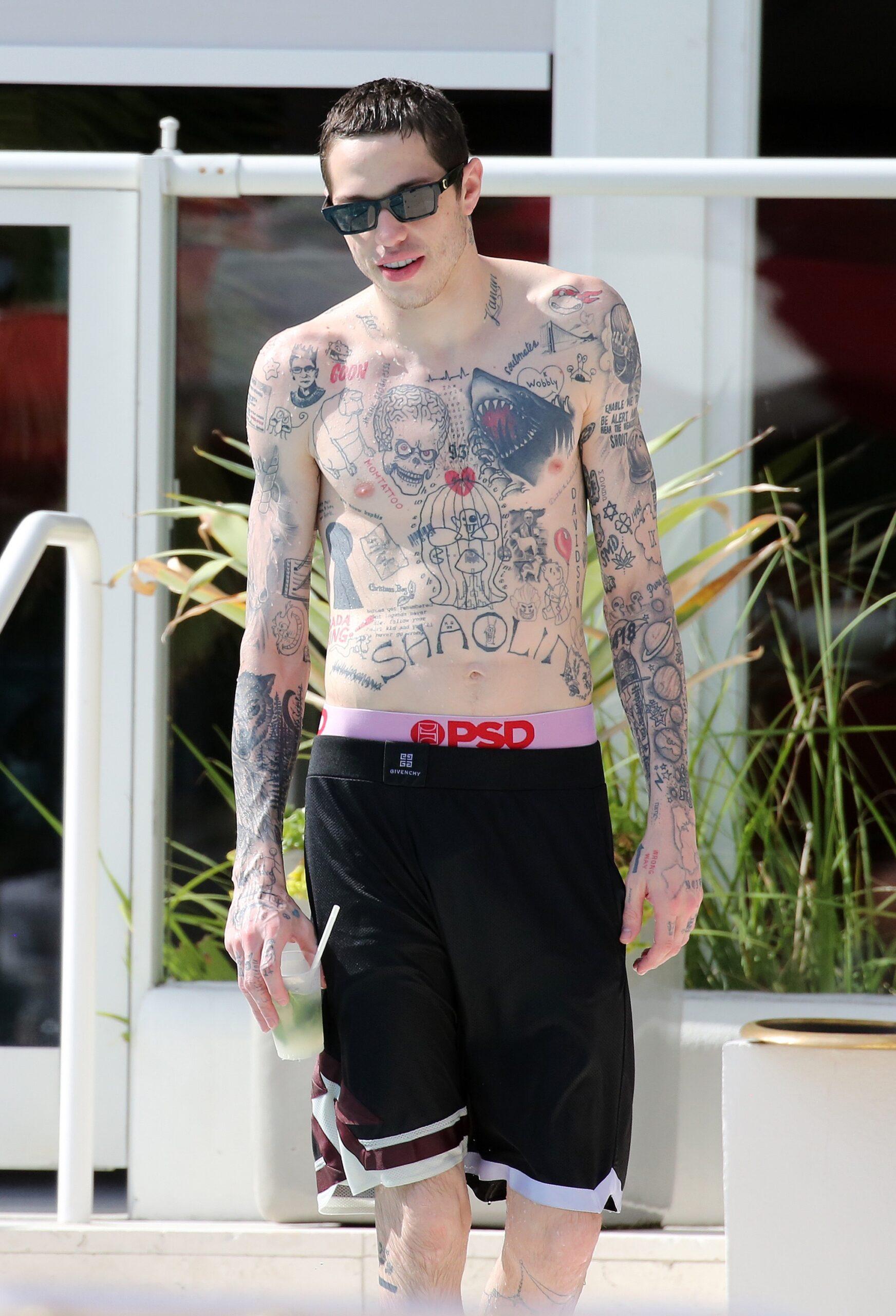 Pete Davidson playfully defends bikini-clad girlfriend Kaia Gerber from paparazzi by using a water gun in between makeout sessions at the pool in Miami