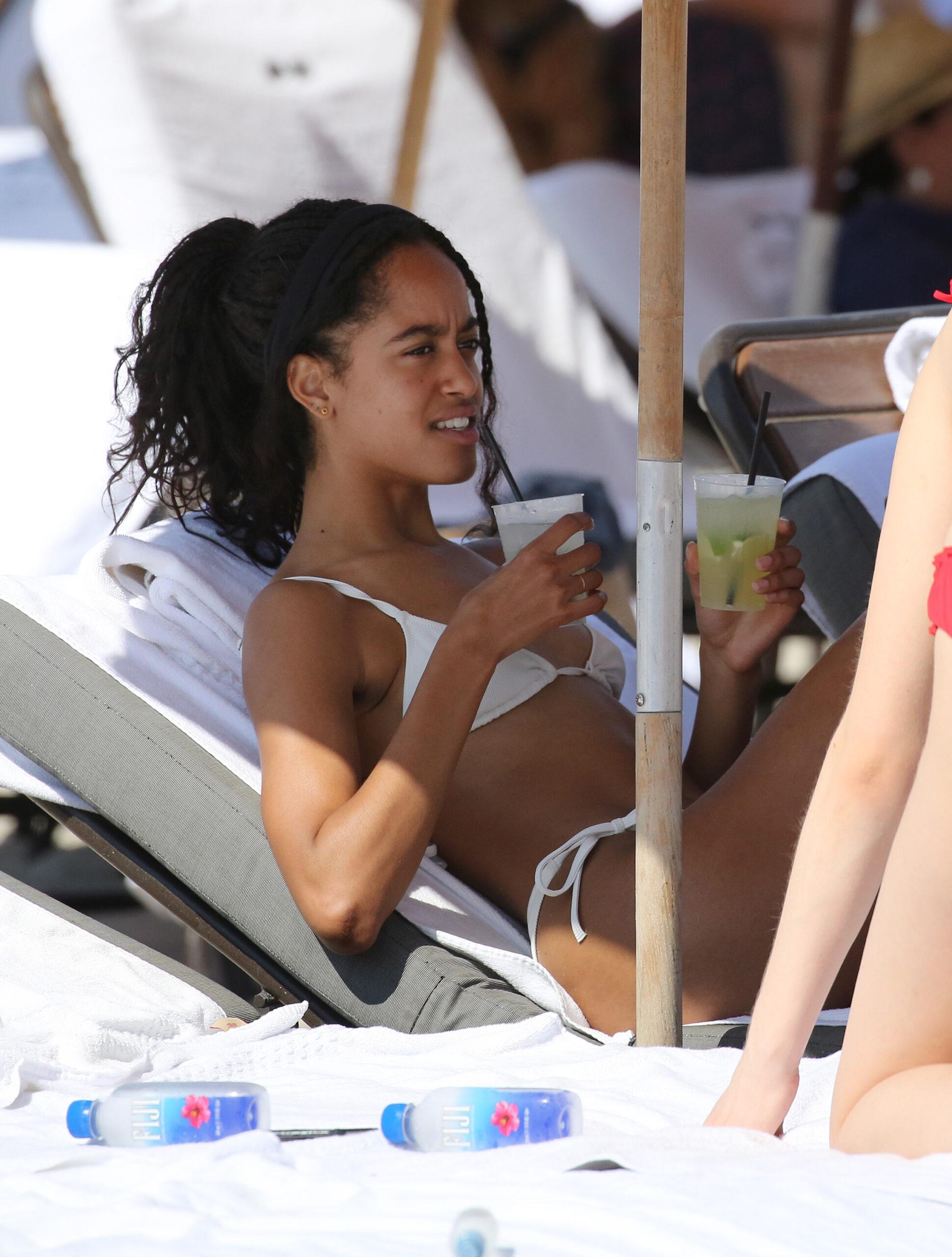 Malia Obama wears a white bikini as she relaxes with friends on the beach in Miami. 16 Feb 2019 Pictured: Malia Obama. Photo credit: MEGA TheMegaAgency.com +1 888 505 6342 (Mega Agency TagID: MEGA361385_003.jpg) [Photo via Mega Agency]