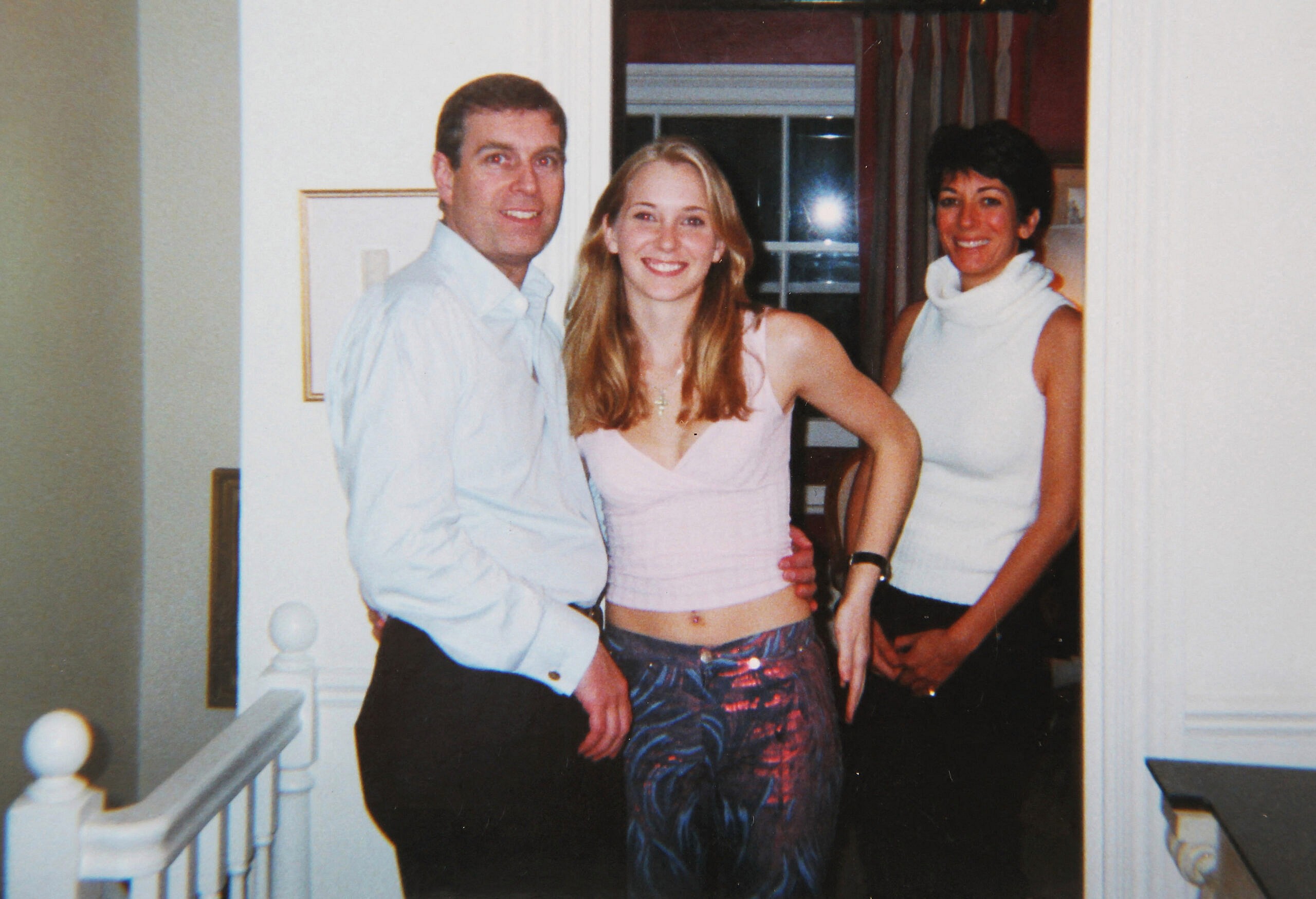 Prince Andrew smiling as he stands with his left arm around the waist of a young Virginia Roberts (now Virginia Giuffre). It is alleged to have been taken in early 2001.