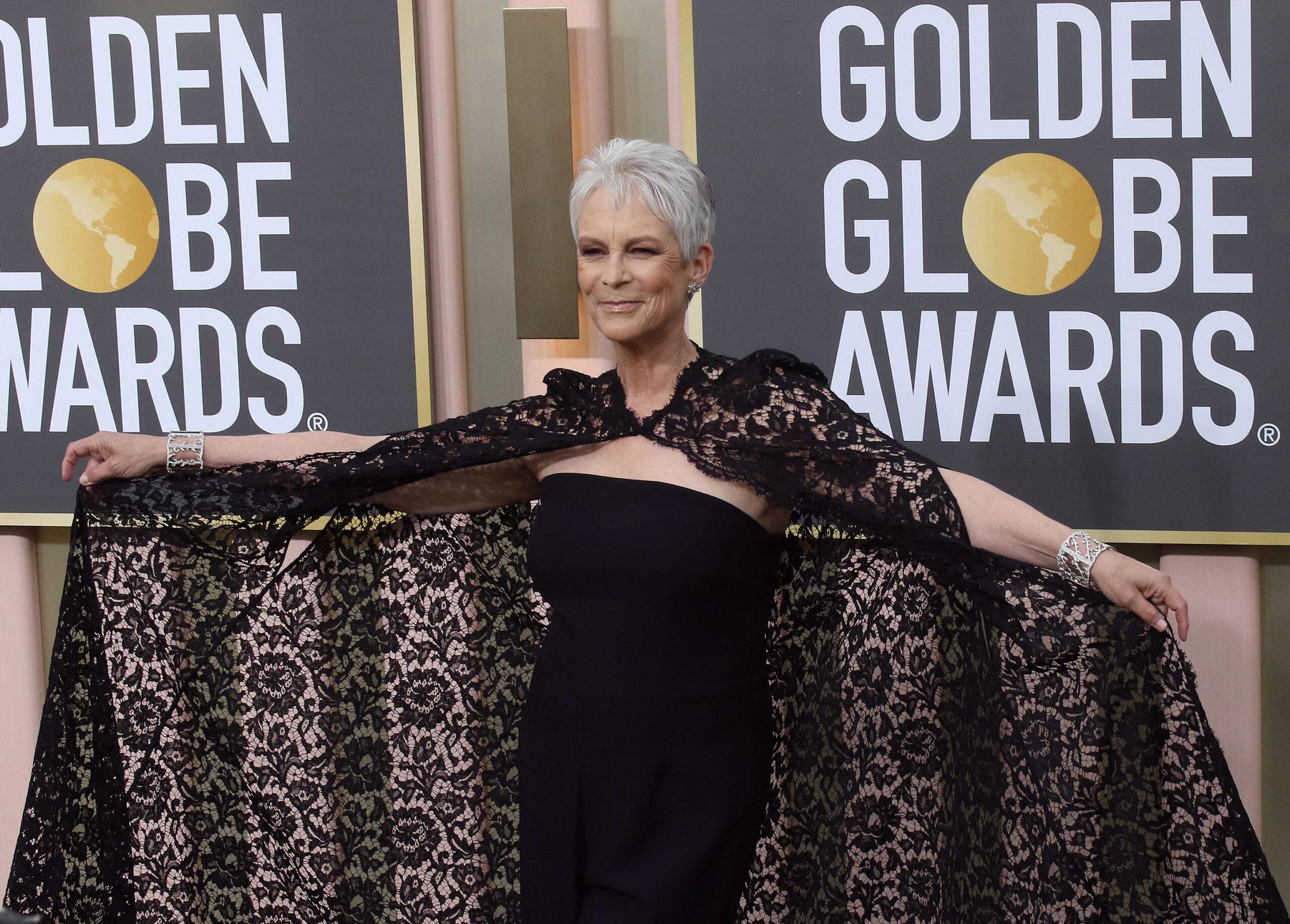 Woman in black lace cape and strapless dress at Golden Globes Awards event