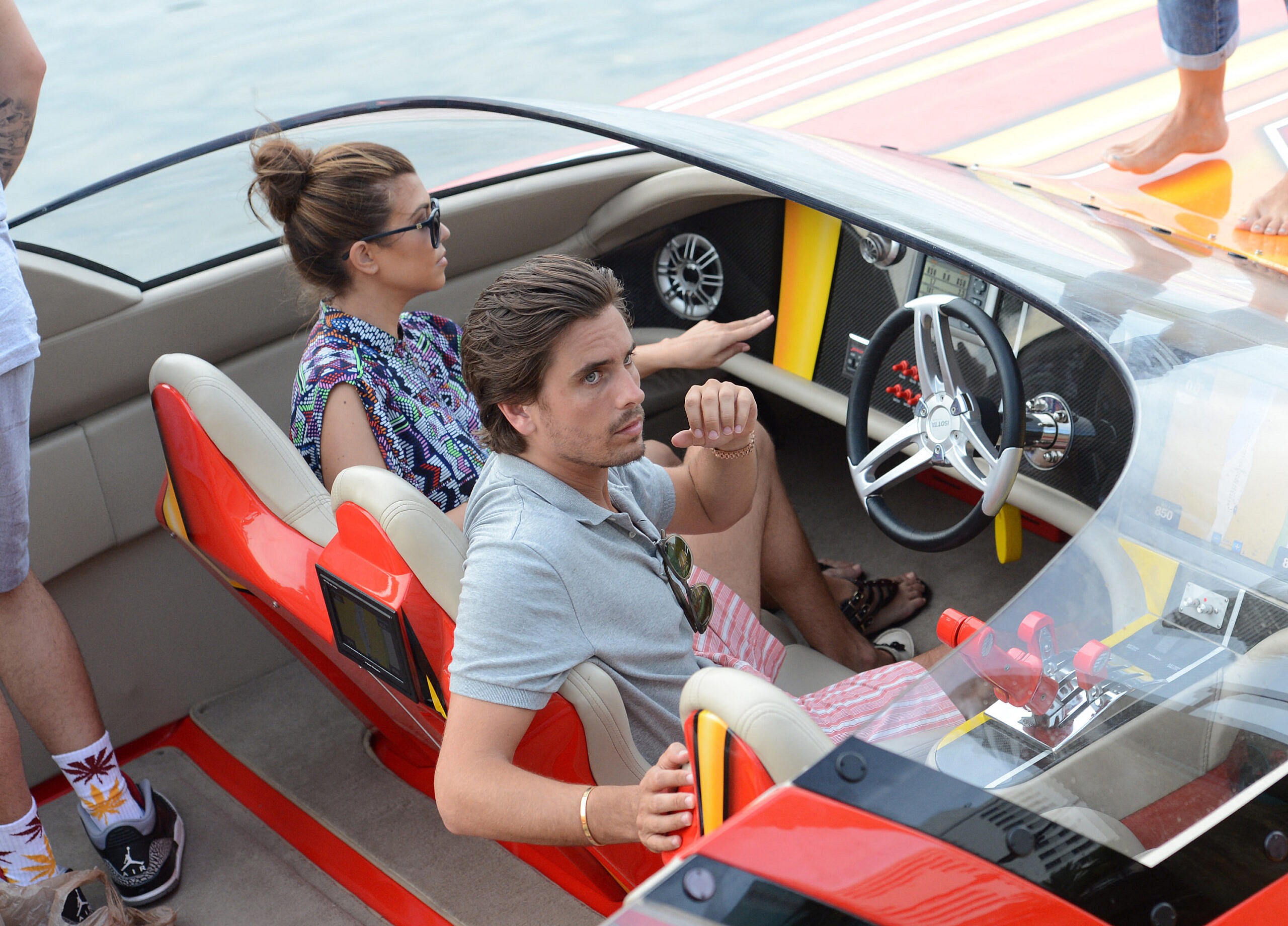 Reality TV stars Kourtney Kardashian and boyfriend Scott Disick take a ride on a red speed boat in Miami Beach