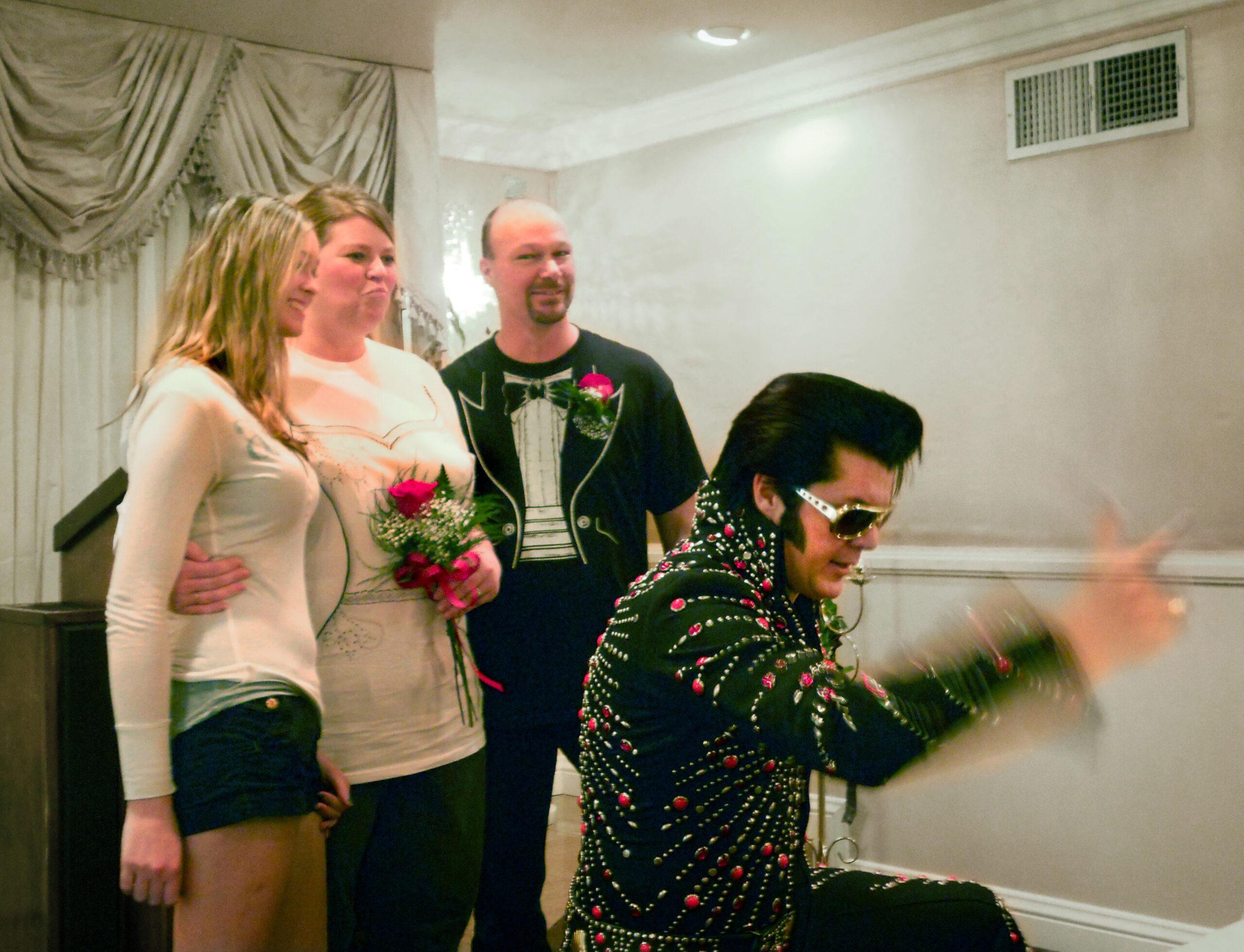 Elvis impersonator poses with wedding couple in chapel