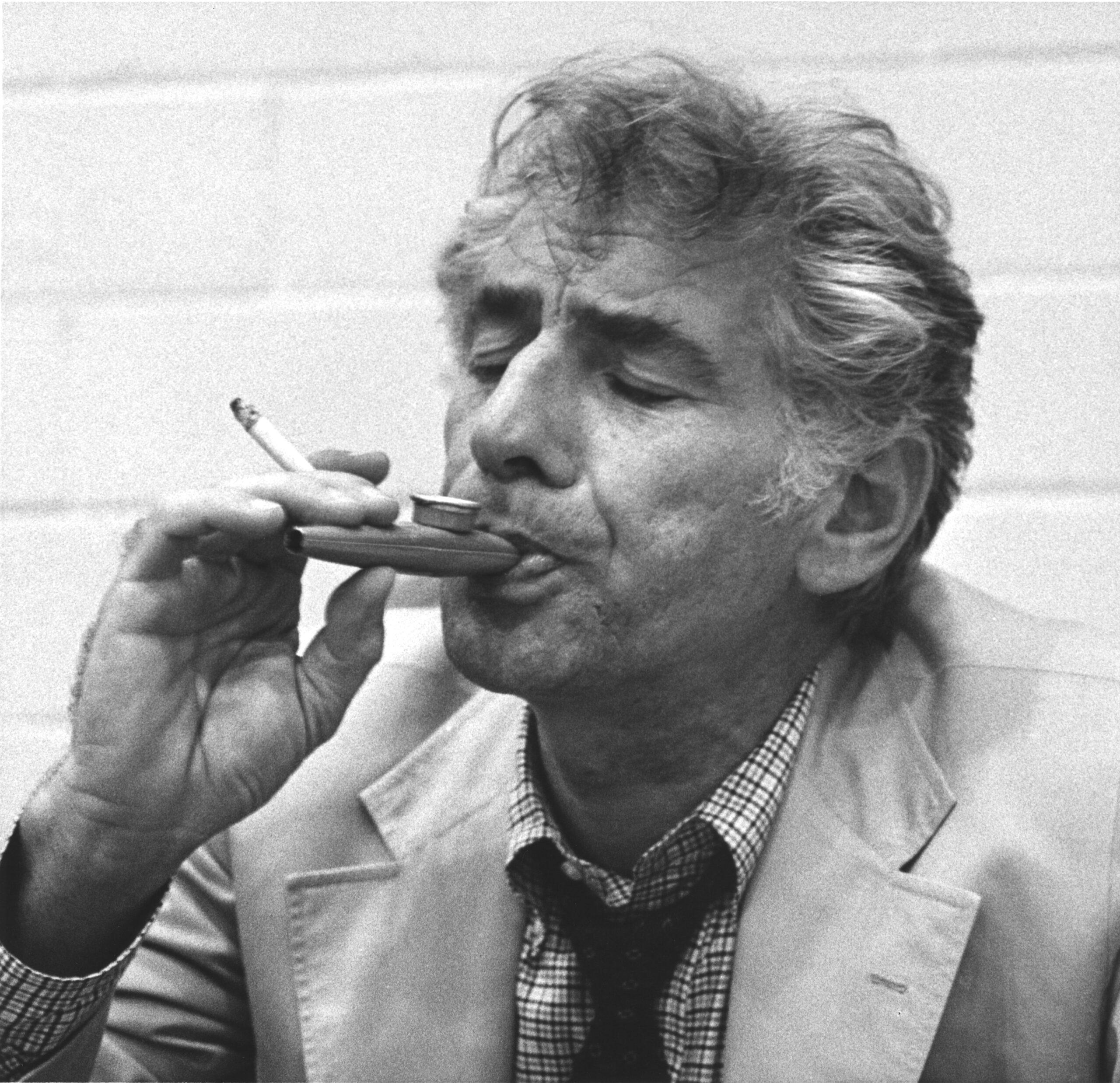 With a cigarette in his hand, conductor-composer Leonard Bernstein still manages to play a kazoo during a rehearsal of his "Mass" at the John F. Kennedy Center for the Performing Arts in Washington on September 2, 1971.