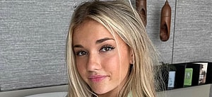 Breckie Hill poses for the camera on the bed.