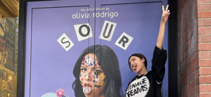 Olivia Rodrigo posing in front of 'Sour' door