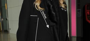 Madonna arriving at Heathrow Airport. She wore sunglasses and an all black outfit, with a fur coat, polkadot trousers and a black Gucci Ghost x Alessandro Michele tote handbag
