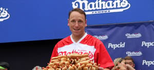 Joey Chestnut holding a plate of hot dogs