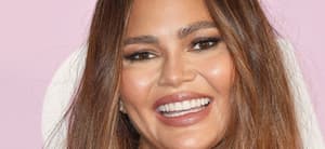 Chrissy Teigen smiles at an event