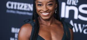 Simone Biles wearing an Aliette dress, Christian Louboutin shoes, and Matteo jewelry while carrying a Judith Leiber bag arrives at the 6th Annual InStyle Awards 2021