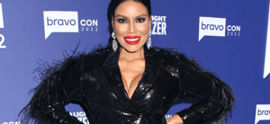 Mia Thornton posing in a black dress on the red carpet.