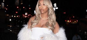 Angel Reese posing in a white dress outside for an event.