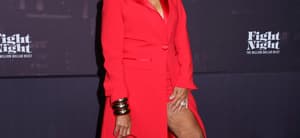 Karen Huger posing in a red dress on the red carpet.