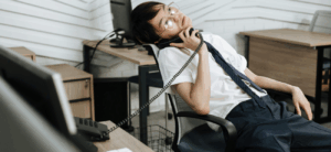 Man slumped over in chair on phone
