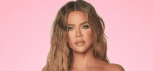 Khloe Kardashian with wavy blonde hair against a pink background