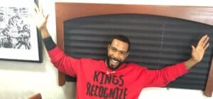 A photo showing Omari Hardwick in a red sweatshirt, with black imprints.