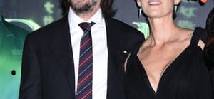 Keanu Reeves and Carrie-Anne Moss posing for the camera.