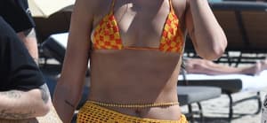 Singer Dua Lipa wears an orange and yellow knit bikini as she hits the beach after a sold out concert in Miami