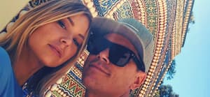 tom and ariana selfie in front of a mosaic