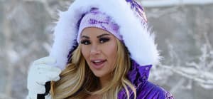 Kindly Myers poses in the snow in a purple snow suit in Utah