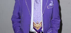 Richard Simmons wearing a purple suit