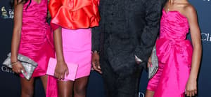 Diddy posing with his daughters on the red carpet.