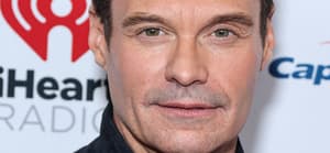 Ryan Seacrest posing for a photo on the red carpet.
