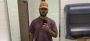 A photo showing Noah Erb taking a mirror selfie in the bathroom