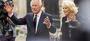 King Charles III and Queen Consort Camilla look at floral tributes left for Queen Elizabeth II outside Buckingham Palace in central London
