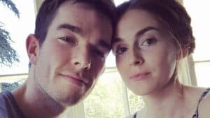 John Mulaney and a woman posing together for a selfie indoors
