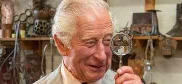 Prince Charles holds up a magnifying glass