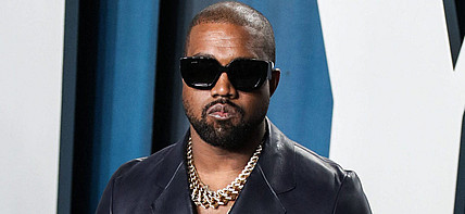 Kanye West wearing a black suit