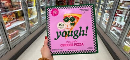 Someone holding up a box of Yough Pizza.