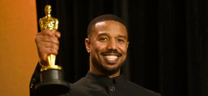 Michael B. Jordan posing with his Oscar on the red carpet.