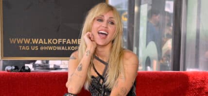 Miley Cyrus posing on the Hollywood Walk of Fame.