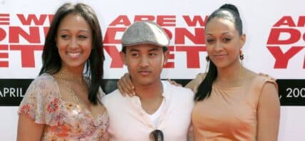 Tahj Mowry posing with sisters Tia and Tamera Mowry.