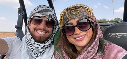 Man and woman with sunglasses smiling for the camera.