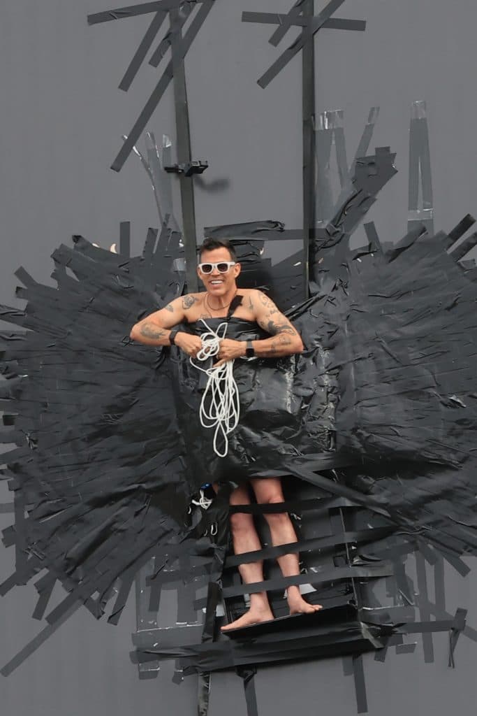 Steve O is helped down by emergency services after duct taping himself to a billboard