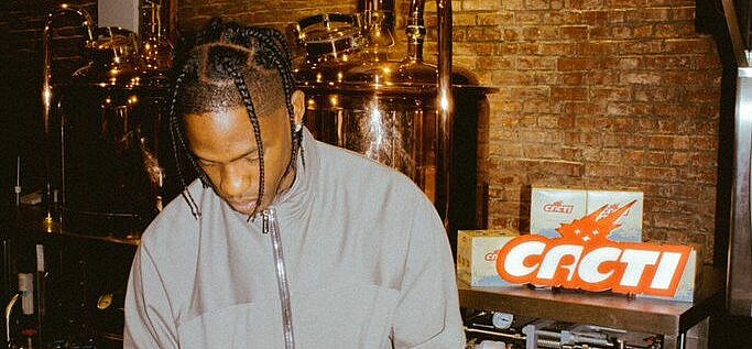 Travis Scott signing CACTI cans.