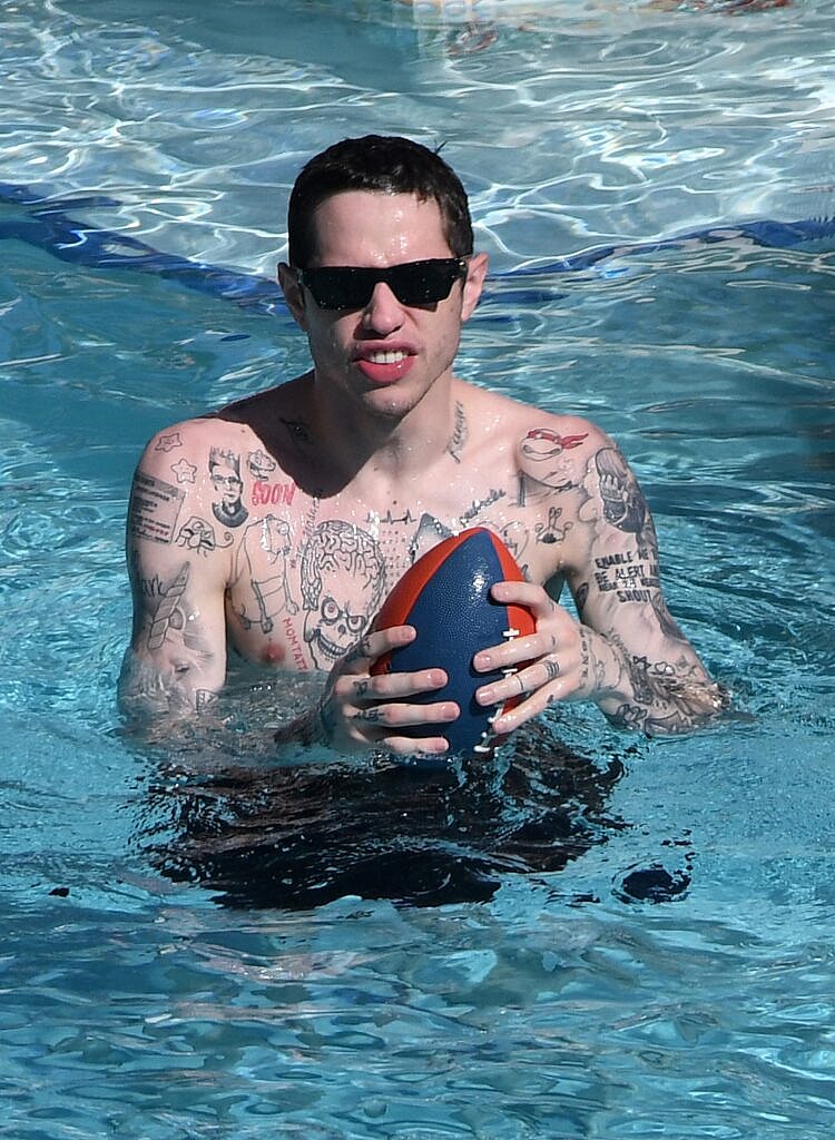 Pete Davidson playfully defends bikini-clad girlfriend Kaia Gerber from paparazzi by using a water gun in between makeout sessions at the pool in Miami