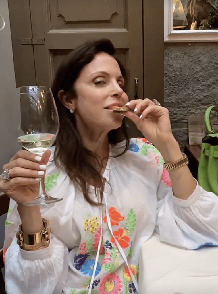 Bethenny Frankel eating pizza and drinking wine