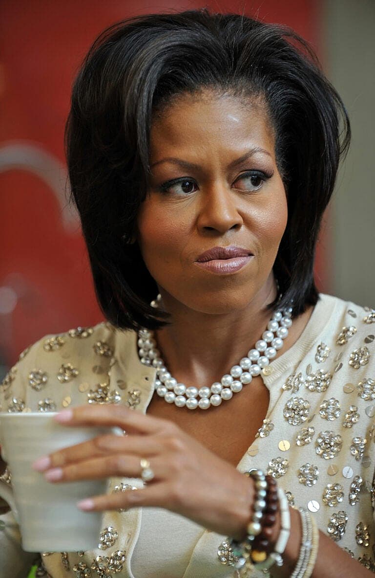 Michelle Obama wearing a beaded cream-colored dress and pearl necklace